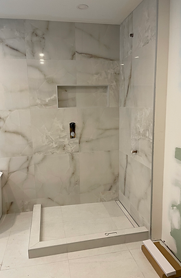 Douche en céramique effet marbre avec niche intégrée, en phase finale de travaux.