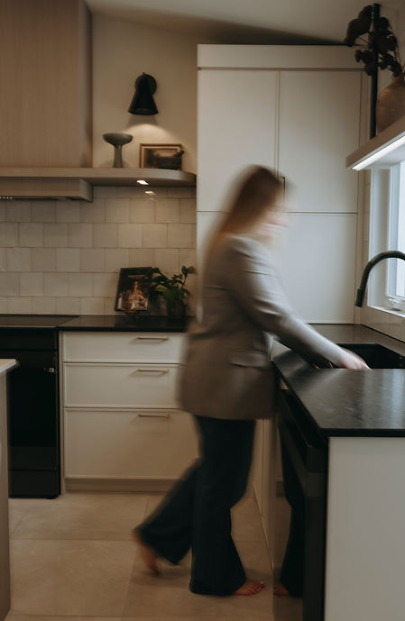 Évier noir encastré dans comptoir clair, robinet noir mat et décor minimaliste.