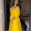 Thumbnail: A Women in Yellow Faux Georgette Gown With Big Flair and Fancy Neck