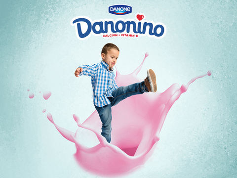 This design shows a young boy kicking the ground but engulfed by a splash of pink Danone yogurt.