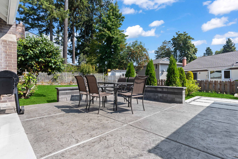 Landscape design and build project in Lakewood, WA, with fireplace, wood pergola, paver patio, and sitting wal