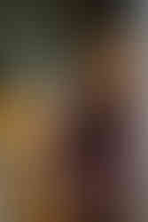 Young woman sitting at a loom pulling warp threads.