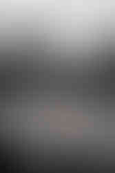 Black and white photo of view over river to bare, winter trees on the far bank