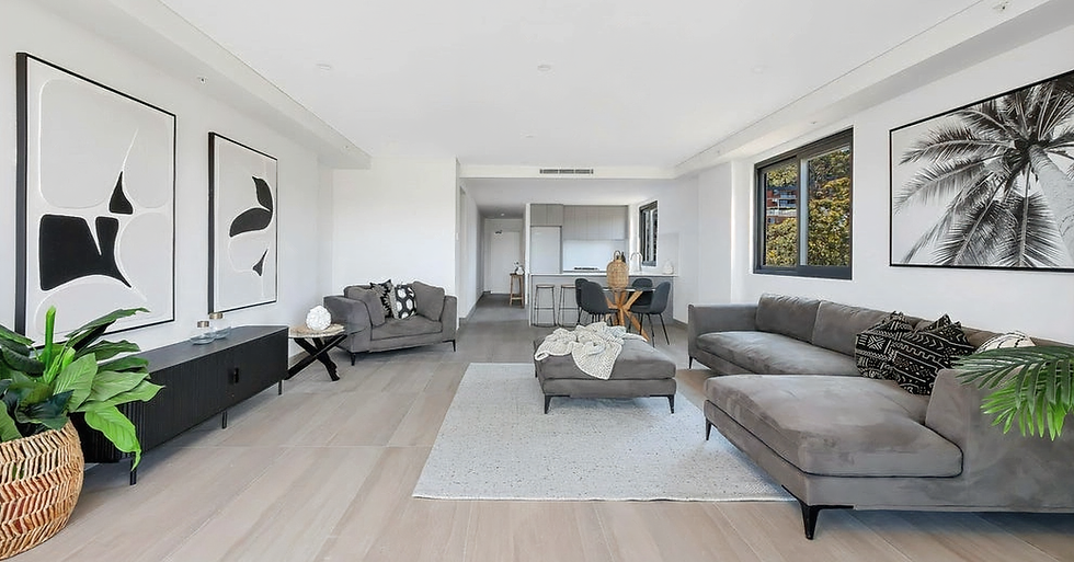 Modern living room with grey couches, white rug, and artwork. 19TEN Design.