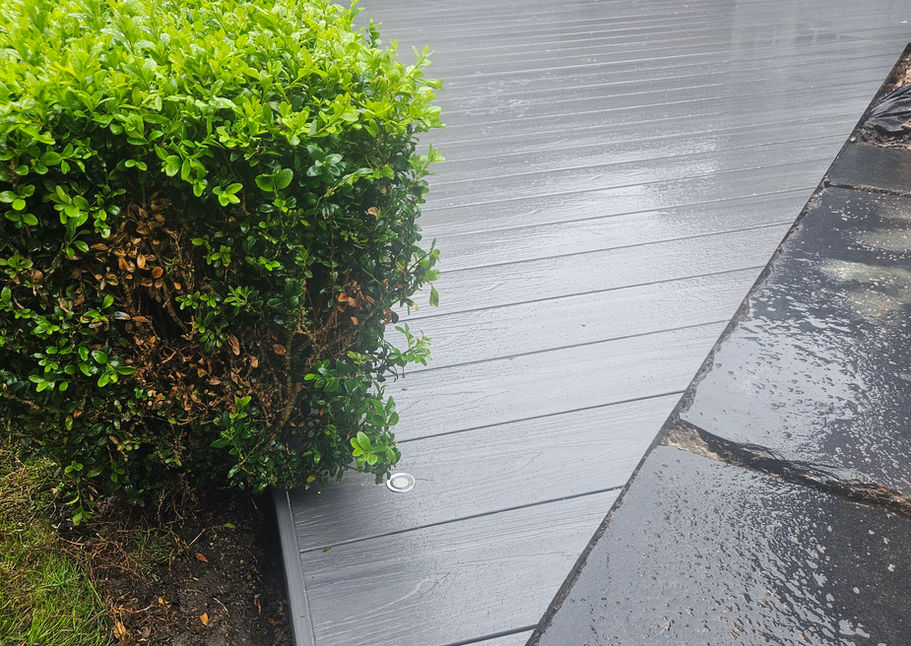 Light grey composite decking installed beside paving and garden planting in Ormskirk.