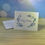 Thumbnail: Happy Birthday Card with blue flowers and writing on a white background sitting on a brown table with a white envelope