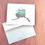 Thumbnail: Alaska state outline with a drawing of a glacier with fireweed landscape inside and on the front of a greeting card