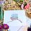 Thumbnail: Greeting card with envelope sitting on a table with flowers around it