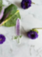Purple Lupine Flower Vinyl Sticker sitting on a marble surface with purple flower blossoms sitting nearby