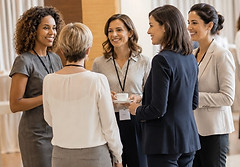 Femmes qui jasent ensemble debout en cercle