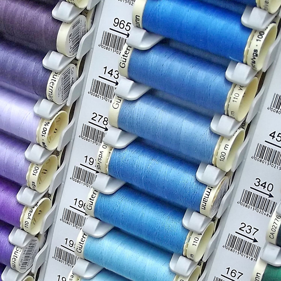 Row of blue and purple thread spools for thread match service