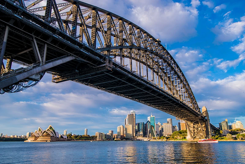 a large bridge over water with Sydney Harbour Bridge in the background