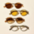 Stack of four stylish round sunglasses in golden and amber tones, showcasing modern designer frames