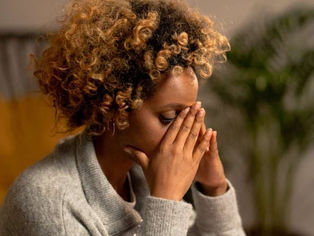 A pair of hands resting on an open book during a quiet sunrise, symbolizing spiritual study and peace.