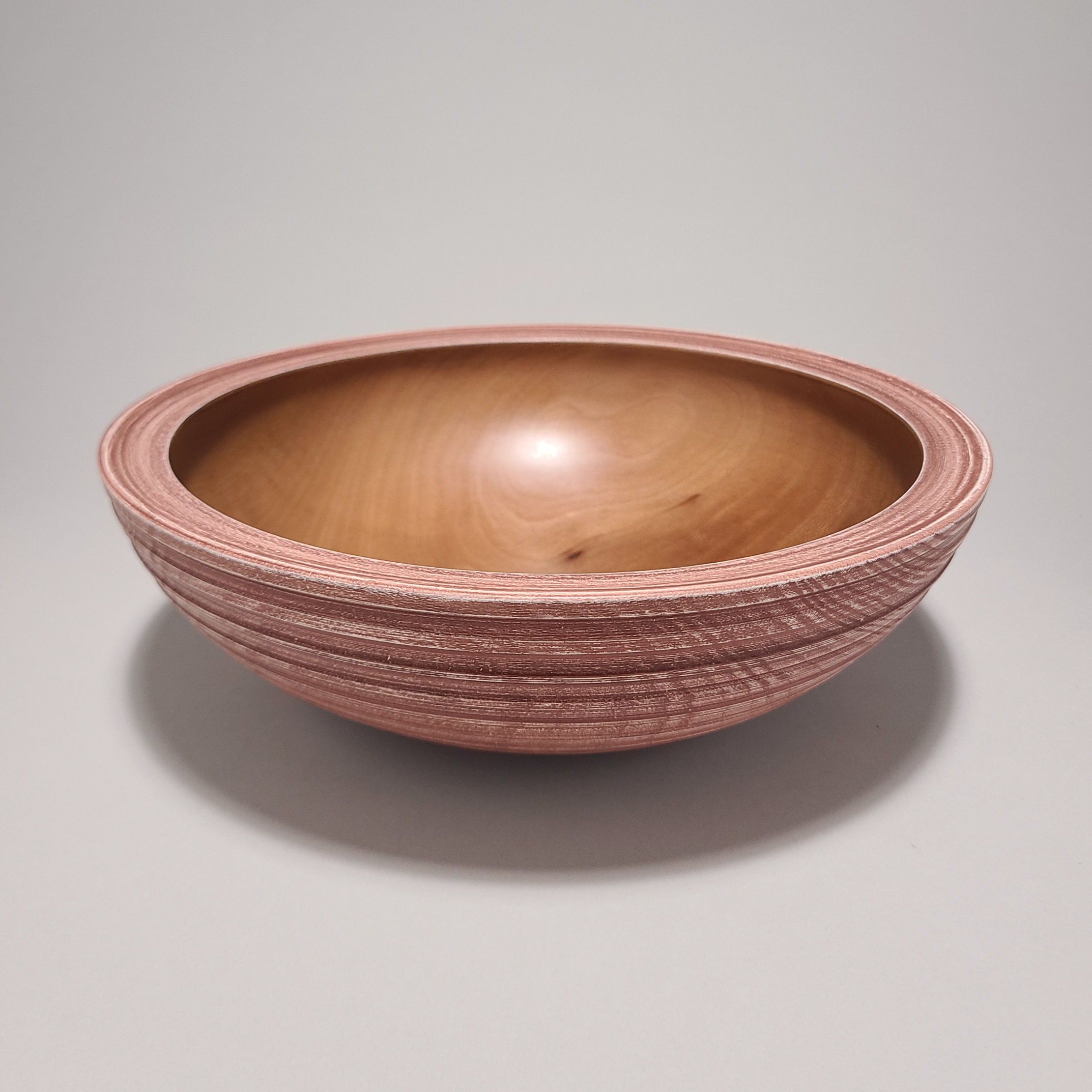 Handturned sycamore wooden bowl with pink milk paint and textured exterior, made from reclaimed neighborhood tree.
