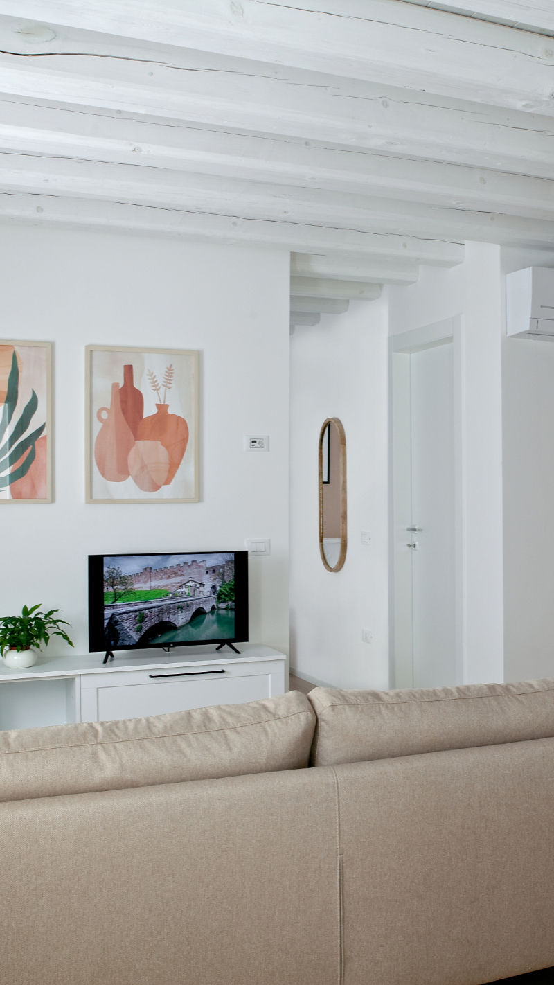 Soggiorno moderno con divano, TV e quadri astratti
