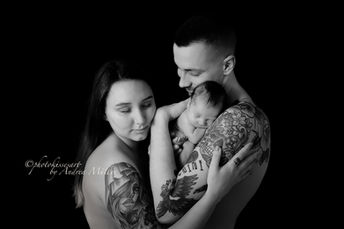 Bild von Eltern mit neugeborenem Baby in schwarz weiss fotografiert von der Fotografin Andrea Müller während eines Neugeborenen Shooting in Langenfeld. Das Fotostudio photokissesart liegt in Langenfeld in der Nähe von Solingen, Leverkusen, Monheim und Leichlingen