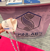 hand holding a badge in a heart shape with Skinlabs logo in the background