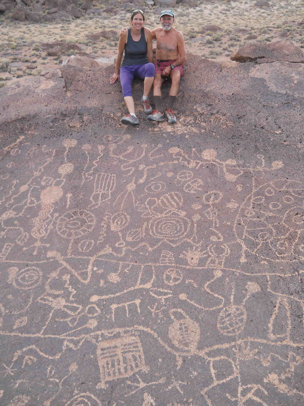 The author and her husband, Jorge, sitting on the rim of a 20-foot-diameter “bowl” of volcanic rock inscribed with ancient Paiute petroglyphs near the Sierra Nevada Mountains of California. Photo courtesy of Joanne Urioste