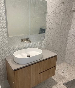 Bright contemporary ensuite bathroom with timber vanity, nickel tapware and terazzo tiles.