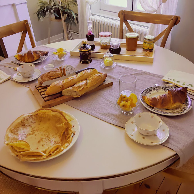 Petit déjeuner avec croissants, crêpes, pain et confitures, La maison botanique.