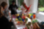 People browsing colorful 3D printed crafts at an indoor market.