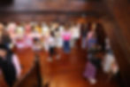 Indoor market with vendors and shoppers in a Nathan Homestead.