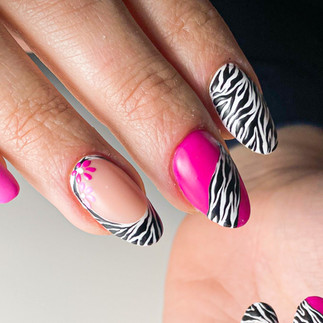 Unghie fucsia con pattern zebrato bianco e nero e fiorellini rosa e fucsia come decorazione