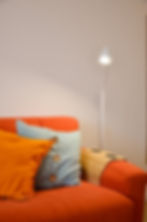 Casa Relli holiday home in Rome South near Tor Vergata – open living area with kitchen and bright orange sofa for relaxing