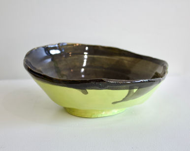 a ceramic bowl with a little green bottom and brown trim