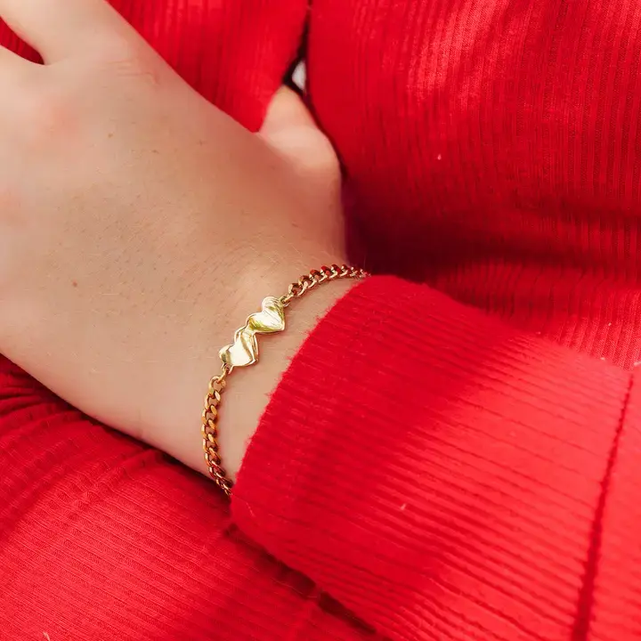 Thumbnail: Gold chain bracelet with two heart charms on a wrist