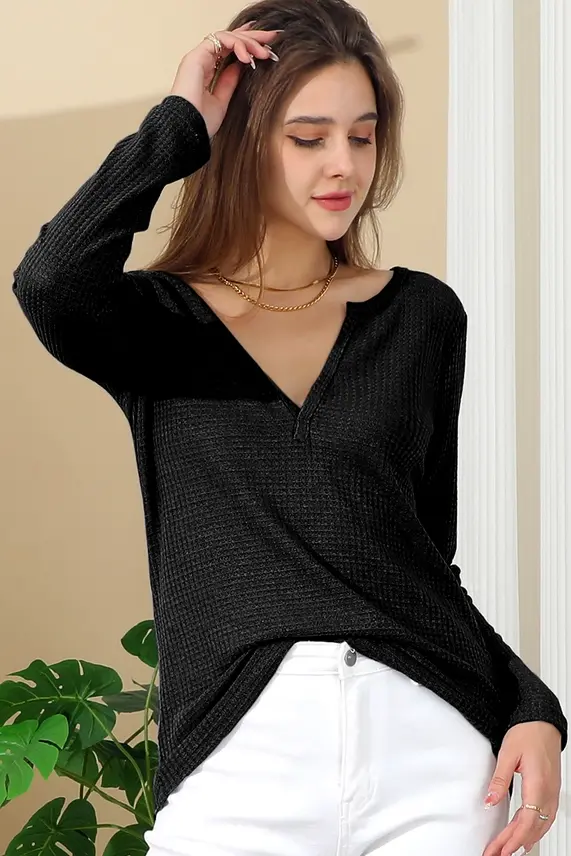 Thumbnail: Woman wearing black V-neck long-sleeve top and white pants