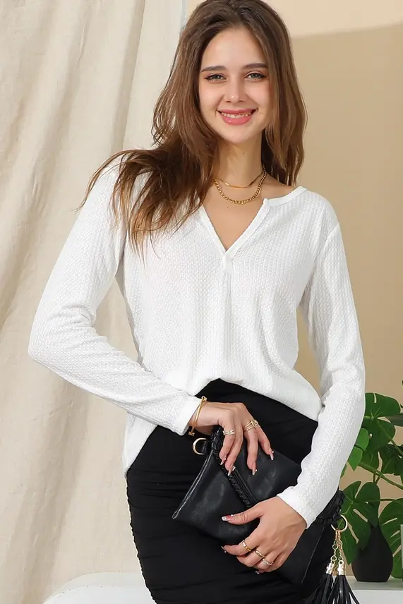 Thumbnail: Smiling woman in white v-neck top holding clutch