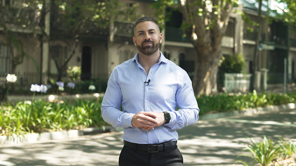 A man in a corporate shirt presenting on a suburban street.