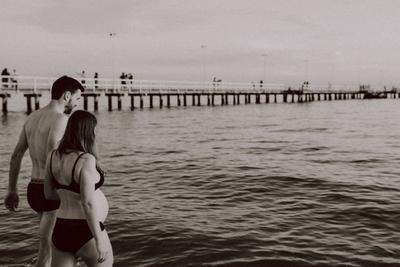 Expecting mum and dad swimming together at Port Melbourne beach.