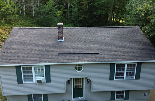 Completed architectural shingle roof replacement with ridge vent and chimney flashing in Winchendon MA