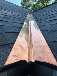 Close-up of hand-formed copper valley flashing integrated with Owens Corning Duration Designer shingles on a roof in Worcester, Massachusetts