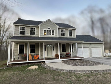 Front exterior beauty shot of a two-story home in Templeton, MA with new Owens Corning TruDefinition Duration Onyx Black shingles and a front porch.