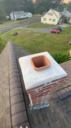 Aerial view of a residential reroofing project featuring a repaired chimney with new lead flashing in Leominster, MA.