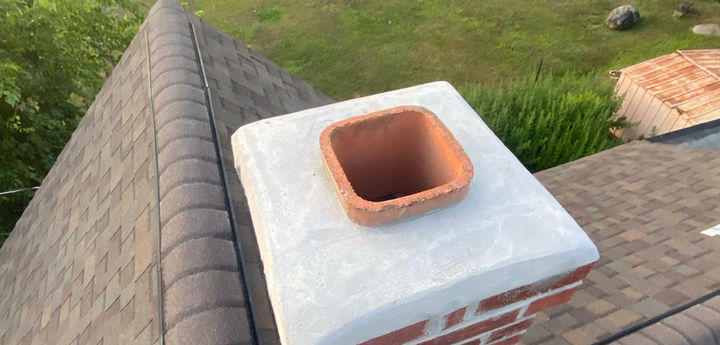 Aerial view of a residential reroofing project featuring a repaired chimney with new lead flashing in Leominster, MA.