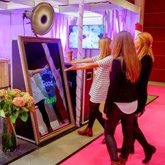 AJs Mystic Mirror's photo booth. Three women taking a photo at an event with the Mirror Me booth rental.