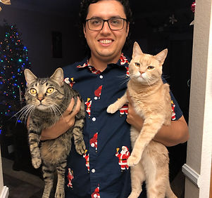 Sean Villareal holding two cats