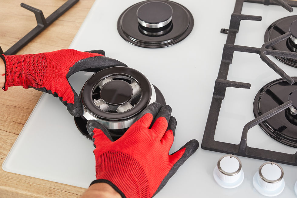 Worker install burner on gas hob in kitchen interior. Repairs of gas control panel.