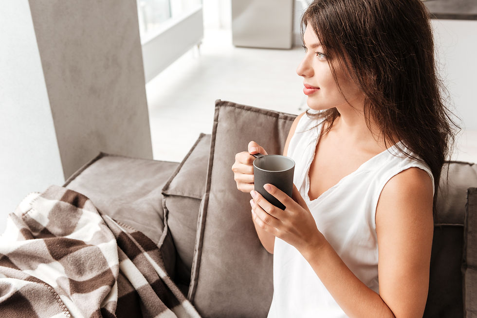 graphicstock-attractive-peaceful-young-woman-sitting-on-sofa-and-drinking-coffee