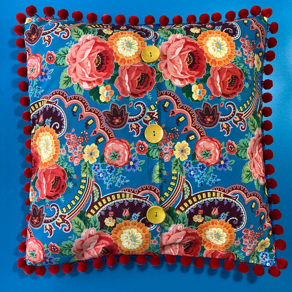 Vibrant floral cushion, red pom-poms