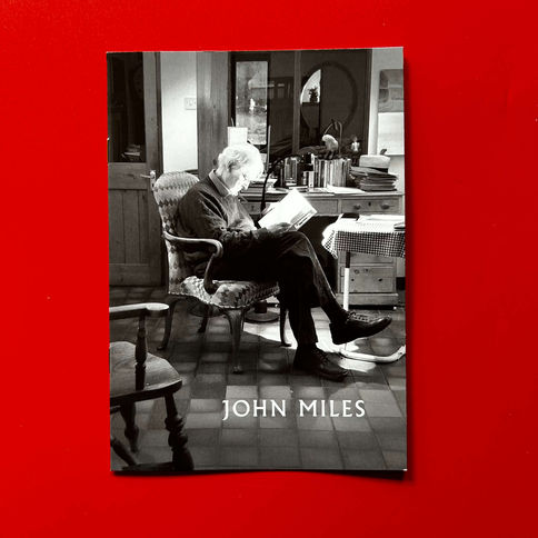 Black and white photo of John Miles reading