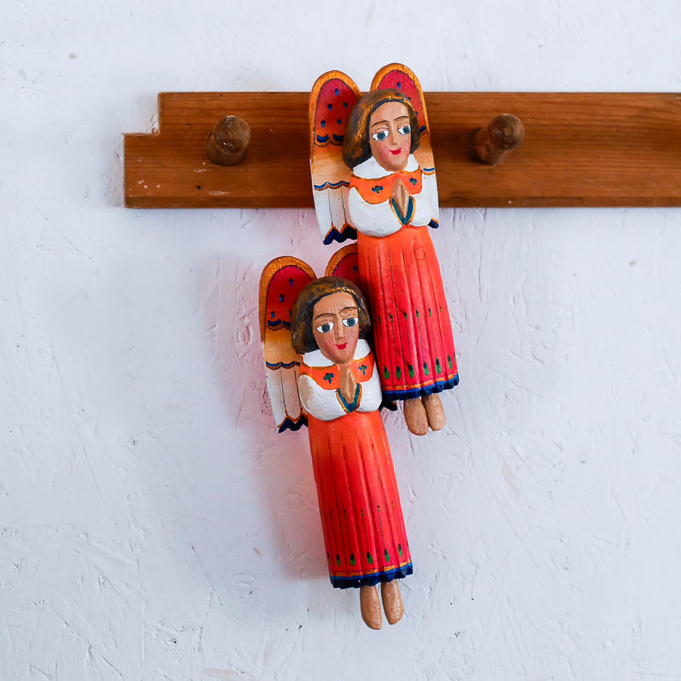 Two wooden angel ornaments hanging on a wall