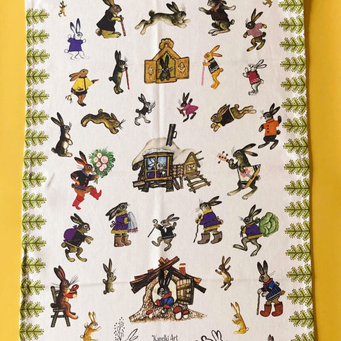 Whimsical tea towel: bunnies frolic around a cozy winter cabin