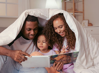 Parents and child happily reading a book together