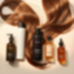Premium hair care products including shampoo, conditioner, and hair oil arranged on a clea